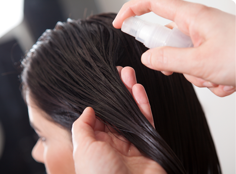 Applying hair spray to damp hair