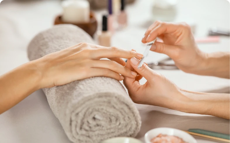Hands receiving nail treatment