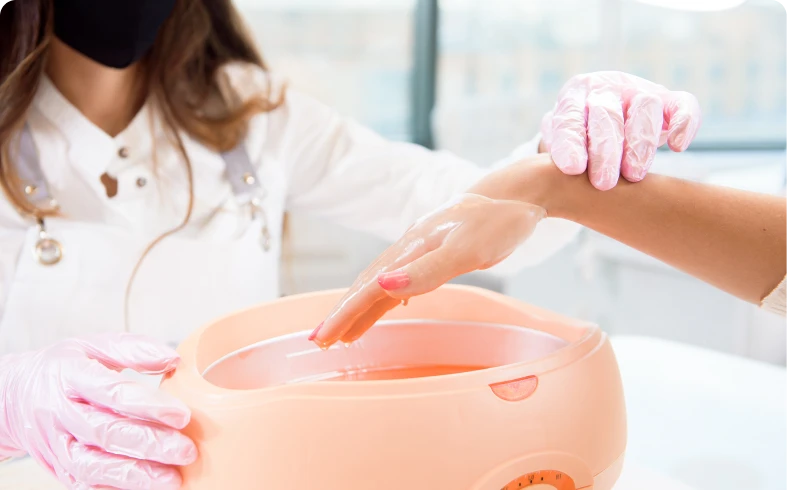 Hand dipping into warm paraffin wax